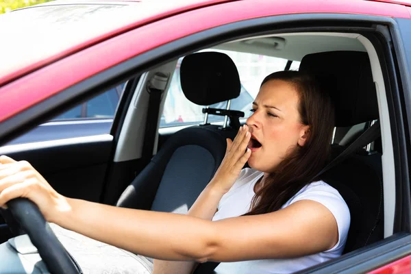 若い女性の車の中あくびの側面図 — ストック写真