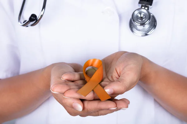 子宮癌意識を示すリボンと女性医師の手のクローズ アップ — ストック写真