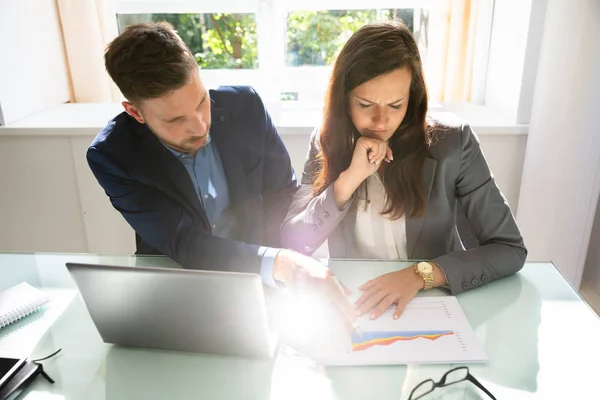 Dos Jóvenes Empresarios Analizando Gráfico Con Computadora Portátil Sobre Escritorio — Foto de Stock