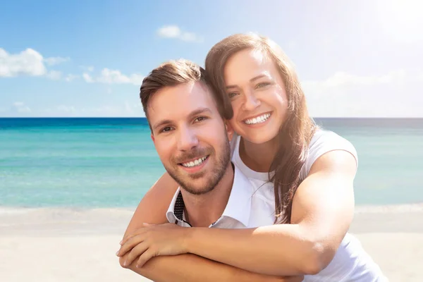 ビーチで楽しんで幸せな若いカップルの肖像画 — ストック写真