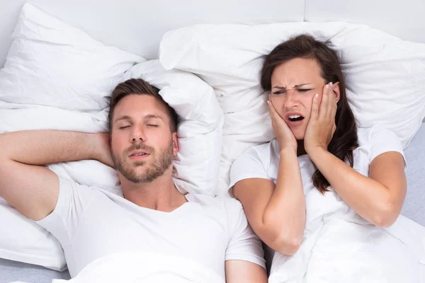 Disturbed Young Woman Covering Her Ears Hands While Man Snoring — Stock Photo, Image