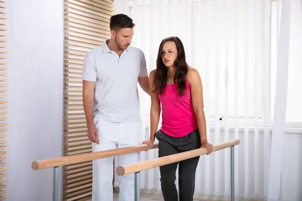 Therapist Assisting Female Patient Walking Support Handrails — Stok Foto