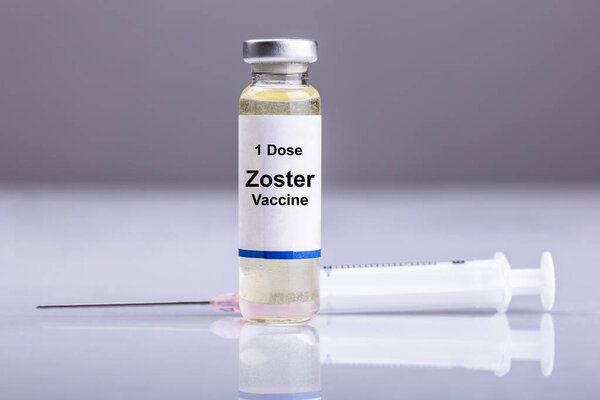 Zoster Vaccine Bottle With Syringe On Reflective Background