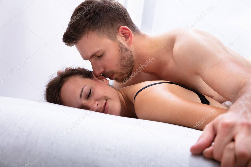 Romantic Young Couple Being Intimate On Bed