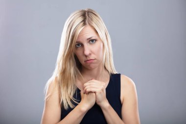 Portrait Of A Sad Young Woman On Grey Background clipart