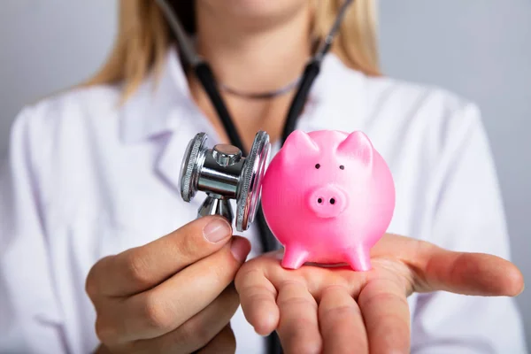 Närbild Kvinna Läkarens Hand Undersöka Rosa Piggybank Med Stetoskop — Stockfoto