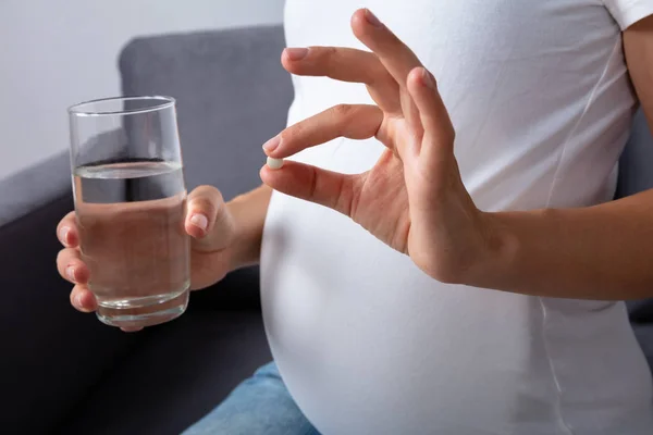 Midsection View Pregnant Woman Glass Water Taking Medicine Home — стоковое фото