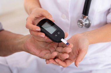 Erkek doktor el şeker ölçüm ile hastanın kan şekeri seviyesi ölçümü