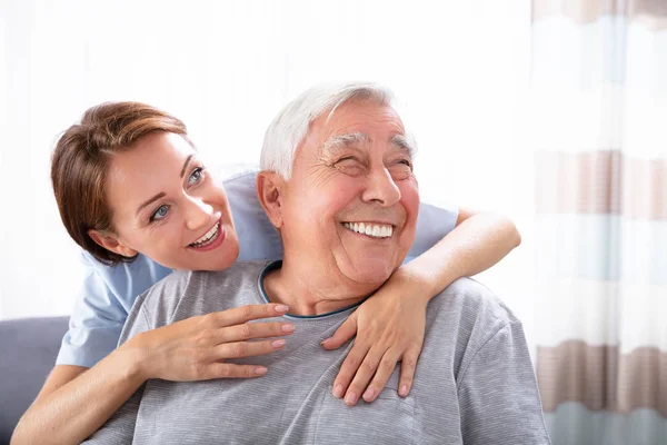 Zbliżenie Happy Pielęgniarka Kobieta Wskazując Coś Starszego Mężczyzny — Zdjęcie stockowe