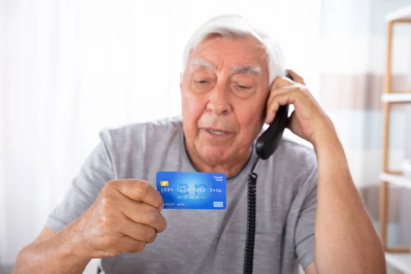 Close Senior Man Credit Card Using Landline Phone — Stock Photo, Image