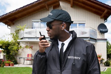 Genç Afrika erkek güvenlik volki tolki evin önünde konuşurken koruma