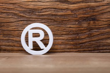 Registered Trademark Sign In Front Of Wooden Wall clipart