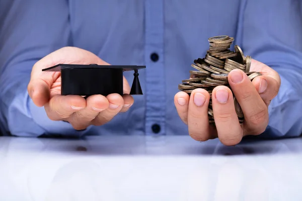 Närbild Persons Hand Hålla Examen Hatt Och Mynt Över Skrivbord — Stockfoto