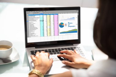Bir iş kadını'nın el laptop Office elektronik tablo inceleyerek Close-up
