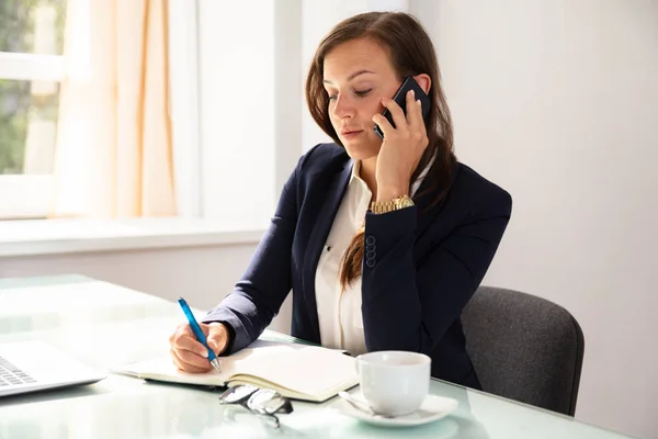 Geschäftsfrau Telefoniert Während Sie Termine Tagebuch Schreibt — Stockfoto