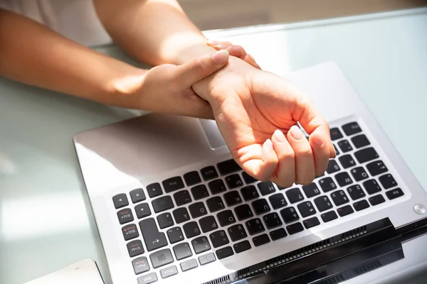 Geschäftsfrau Hält Schmerzhaftes Handgelenk Mit Laptop Auf Schreibtisch — Stockfoto