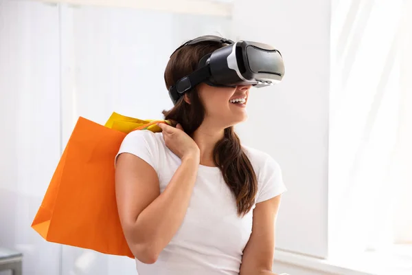 微笑的年轻女子使用虚拟现实设备在家里购物的经验 — 图库照片