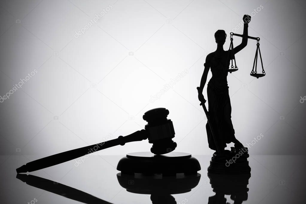 Statue Of Justice And Gavel On Reflective Background