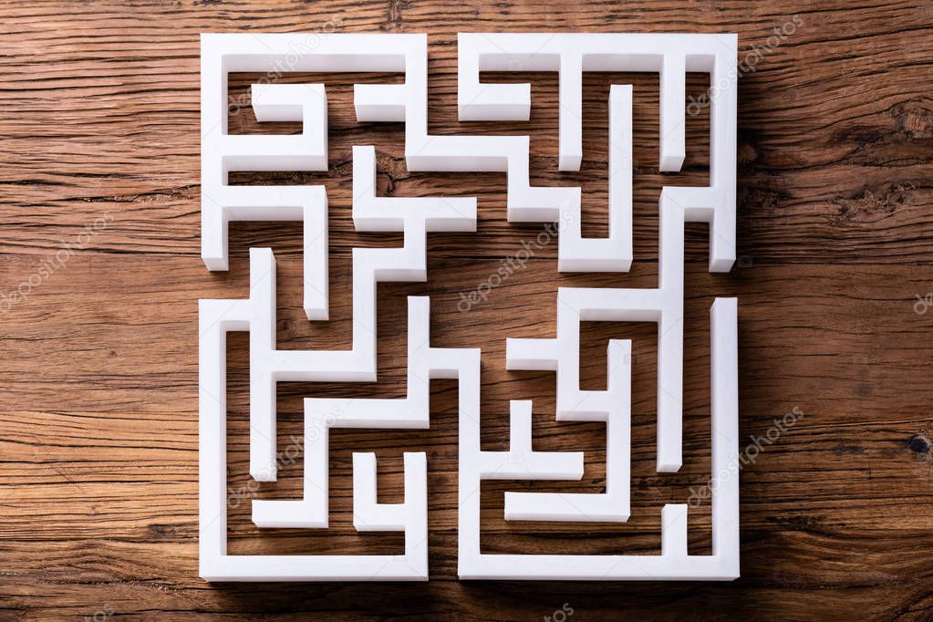 Overhead View Of Abstract White Maze On Wooden Background