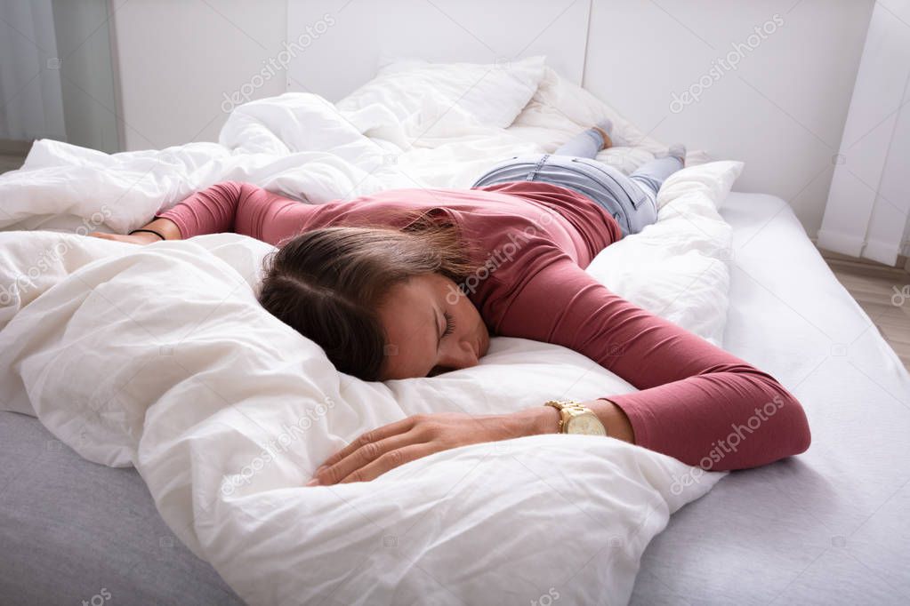 Young Woman Sleeping On Bed In Bedroom