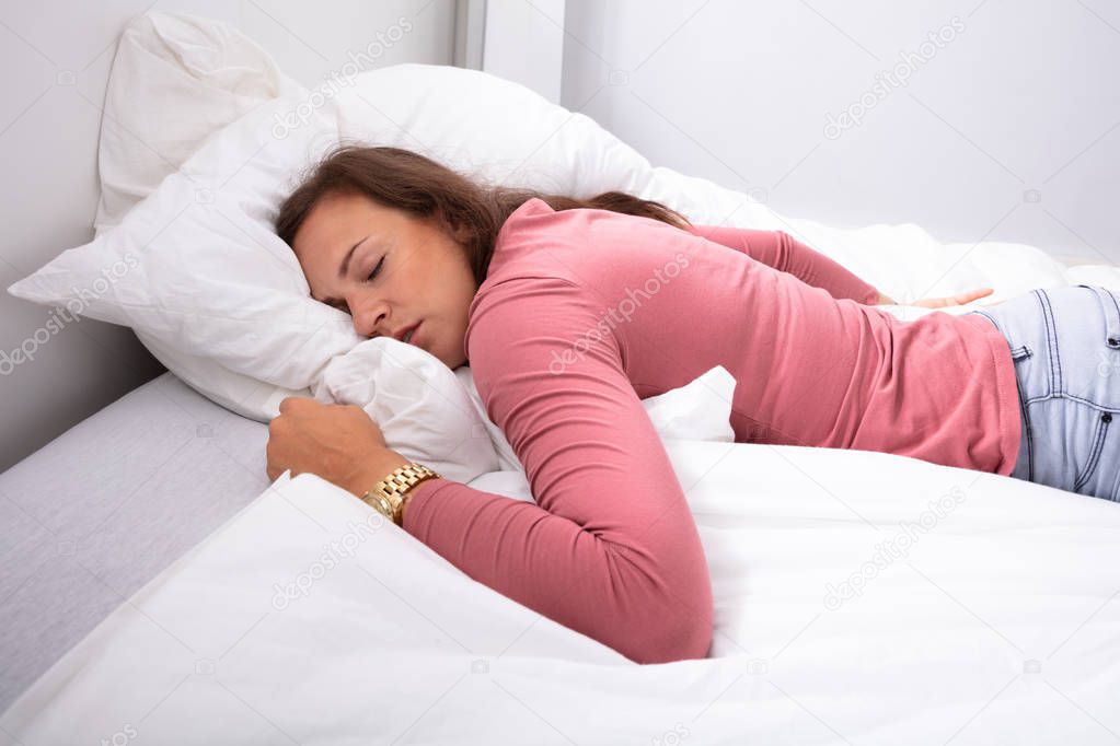 Young Woman Sleeping On Bed In Bedroom
