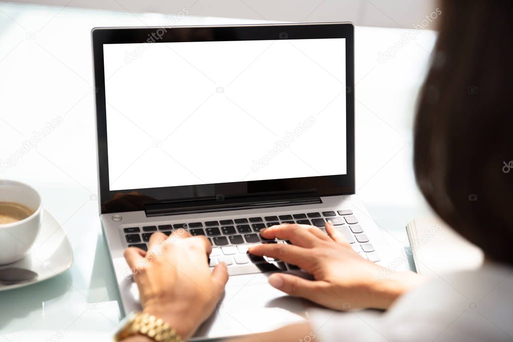 Businesswoman's Hand Using Laptop With Blank White Screen