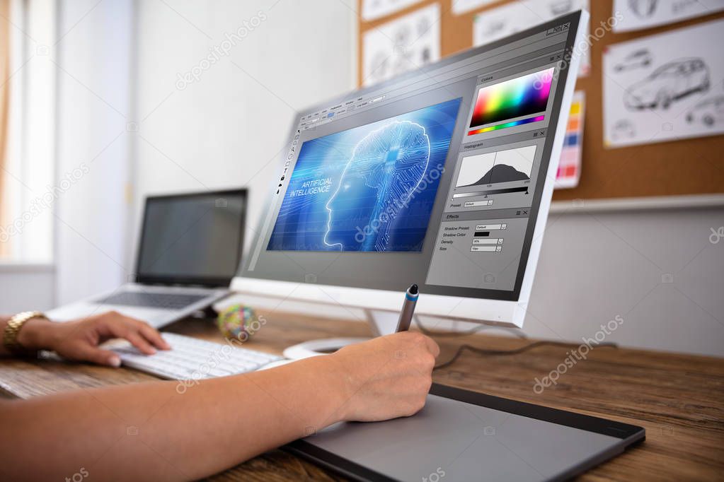 Female Designer Using Graphic Tablet While Working On Computer