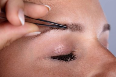 Cımbız ile kaş saç koparma bir el Close-up