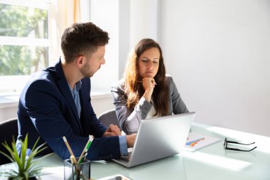 Ofis Masası dizüstü bilgisayar ile grafik analiz iki genç iş adamları