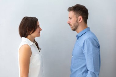 İki iş adamları birbirine önünde gri arka plan bakarak
