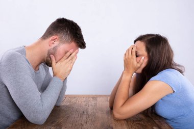 Depresif genç bir çiftin karşılıklı oturup yan görünüm