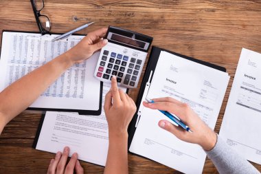 Bill ahşap arka plan üzerinde hesap makinesiyle hesaplama çift yükseltilmiş görünümü