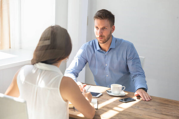 Two Young Businesspeople Having Conversation At Workplace