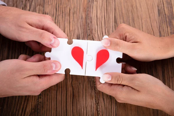 Verhoogde Weergave Van Een Paar Aansluiten Rood Hart Puzzel Samen — Stockfoto