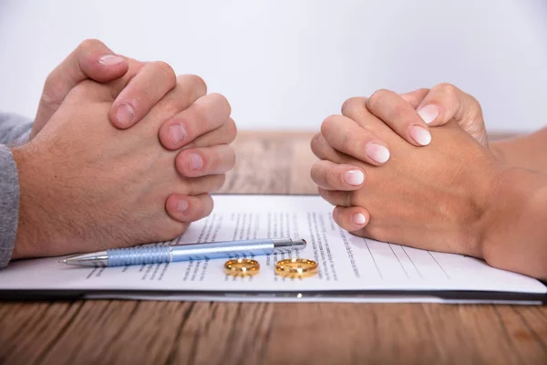 Mão Casal Com Acordo Divórcio Anéis Casamento Dourados Mesa Madeira — Fotografia de Stock