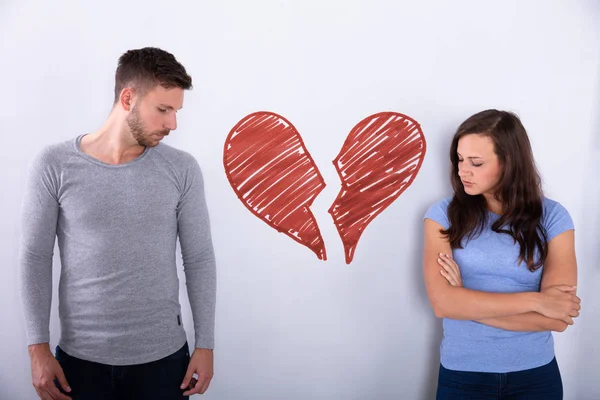 Corazón Rojo Roto Dibujado Pared Entre Pareja Joven Triste —  Fotos de Stock