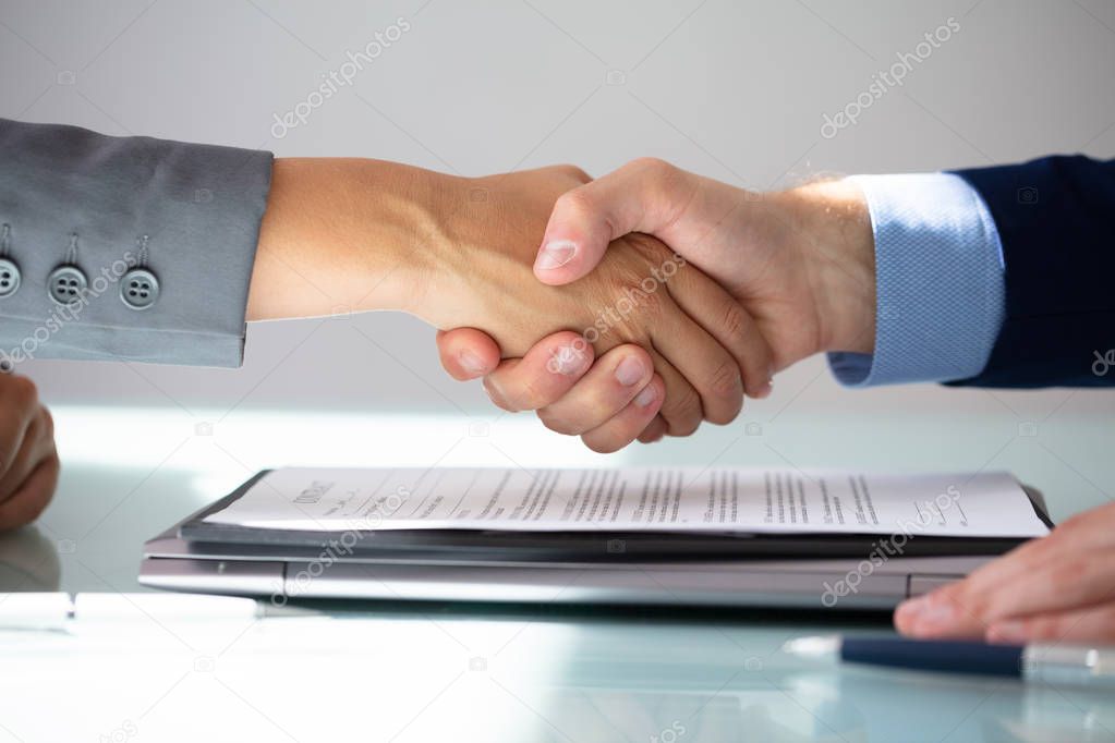 Business Partners Shaking Hands Over Contract Form