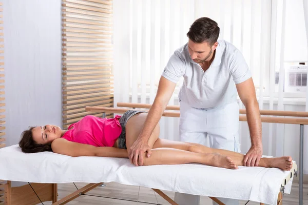 Manliga Terapeutens Hand Massera Kvinnans Ben Klinik — Stockfoto