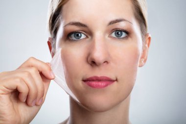 Yüzünü maske Peeling kaldırma güzel bir genç kadının portresi