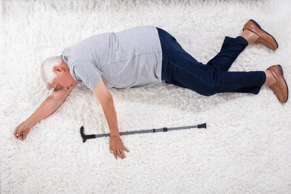 Omedvetna Senior Man Med Käpp Ligga Mattan Hemma — Stockfoto