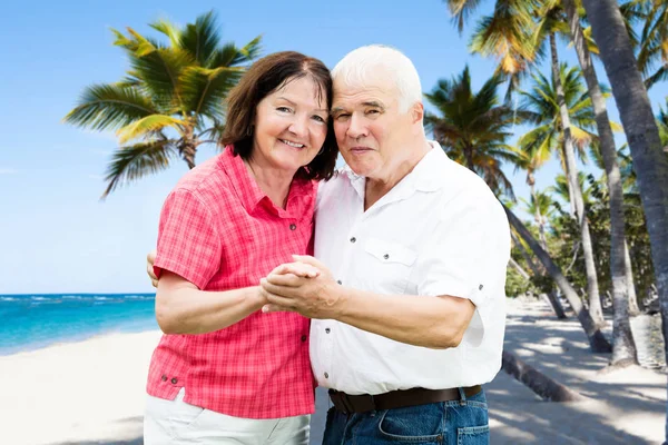 一个高级夫妇拿着手塔海滩的肖像 — 图库照片