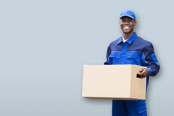Smiling Male African Mover Holding Package Gray Background — Stock Photo, Image