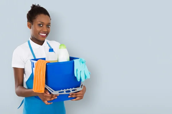 Portret Van Een Lachende Afrikaanse Vrouwelijke Janitor Holding Reinigingsapparatuur — Stockfoto