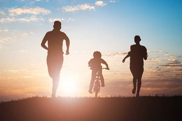 Silhueta Pais Correndo Com Seu Filho Andar Bicicleta Pôr Sol — Fotografia de Stock
