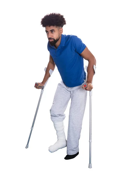 用拐杖在白色背景的腿折断的人 — 图库照片