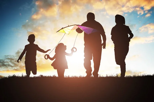 Silhueta Família Divertindo Enquanto Voa Pipa Colorida Durante Pôr Sol — Fotografia de Stock