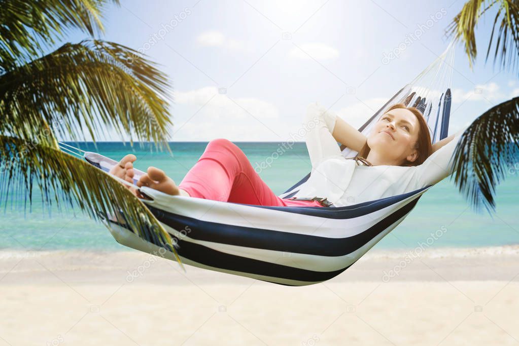 Close-up Of A Smiling Woman Relaxing In Hammock At Beach