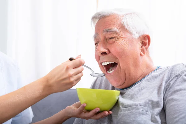 Närbild Caretaker Hand Utfodring Senior Mannen — Stockfoto