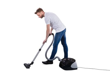 Beyaz arka plan üzerinde elektrik süpürgesi kullanan adam