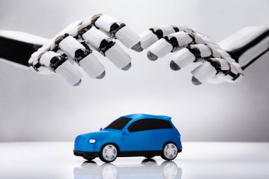 Yansıtıcı masa mavi araba koruyan bir robot el Close-up